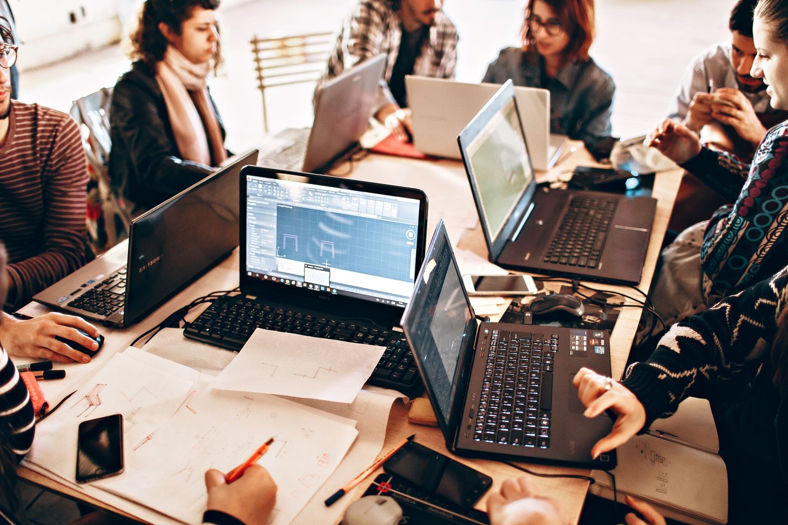 Equipo de desarrollo de seis personas discutiendo prioridades técnicas en una reunión de trabajo